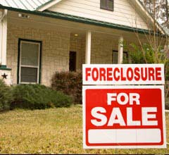 A foreclosure sign in front of a house.